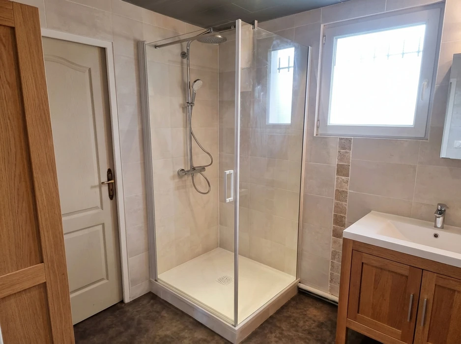 Salle de bain rénovée avec douche à l'italienne en cabine intégrale, parois en verre transparent, receveur blanc extra-plat