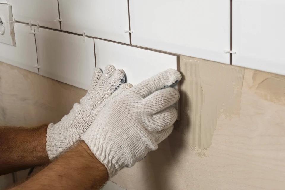 Intérieur salle de bain, mains d'artisan réparant robinet mitigeur chromé moderne sur plan vasque marbre noir