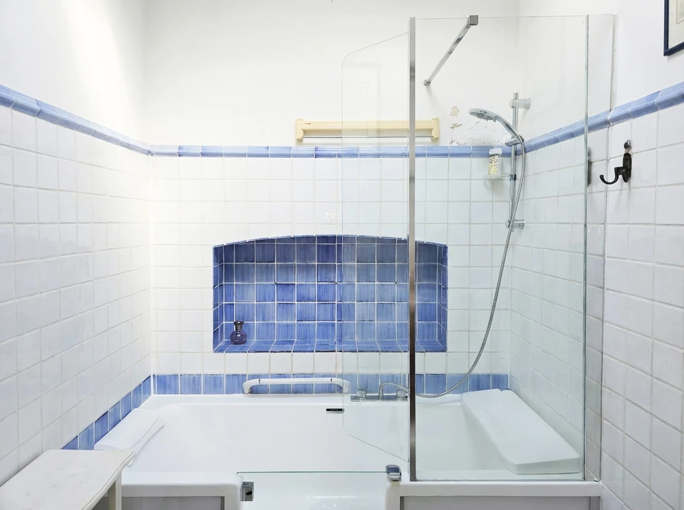 Salle de bain moderne avec douche &agrave; l'italienne, WC et vasque encastr&eacute;e dans plan de travail noir