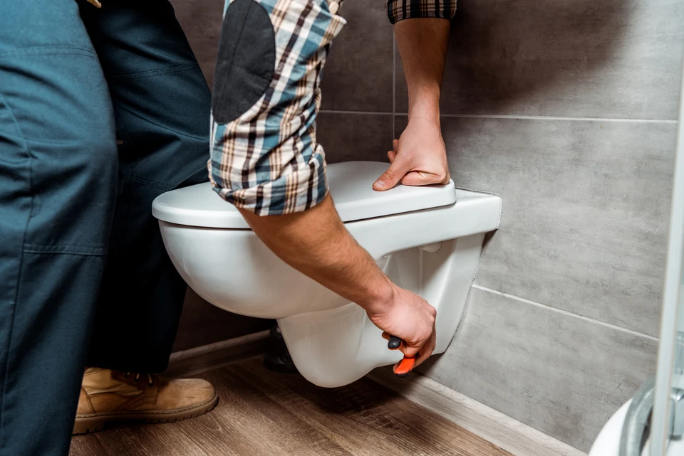 Photographie d'une salle de bains moderne entièrement accessible PMR : vue d'ensemble montrant une douche de plain-pied avec receveur extra-plat, barres de maintien en chrome fixées stratégiquement au mur, robinetterie mitigeur accessible, espace de circulation dégagé permettant l'accès en fauteuil roulant, sol antidérapant, miroir positionné à hauteur accessible. L'image doit transmettre professionnalisme, modernité et adaptation fonctionnelle pour personnes à mobilité réduite.